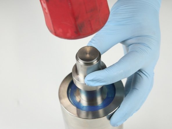 Hit the push tool with a rubber mallet to push the second hoop and the high-pressure seal assembly out of the high-pressure cylinder.