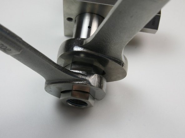 Loosen the 3/8" to 1/4" adapter from the outlet fitting using a 7/8" and 13/16" wrench.