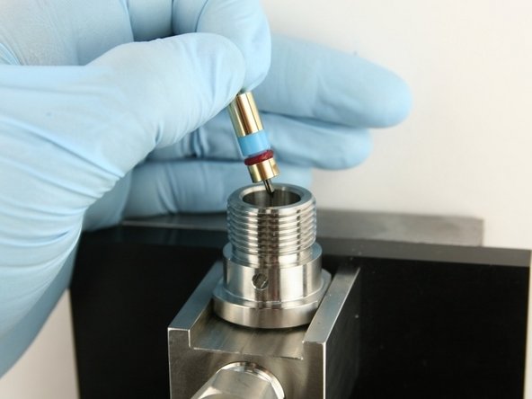 Put the poppet stem, with the point down, at the top of the valve body.