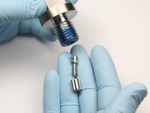 Remove the high-pressure spring, poppet pin, and poppet valve from the high-pressure sealing head gland.