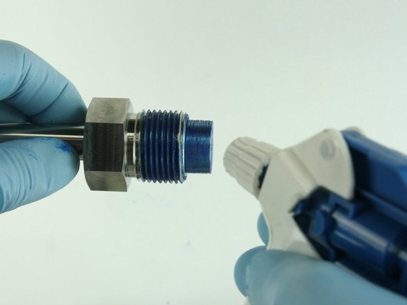 Clean the valve nut threads and the top of the  nozzle tube of all Blue Goop.