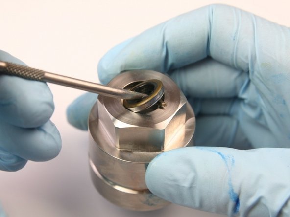 Remove the metal capped wiper from the cavity of the bearing half of the swivel housing with a pick.