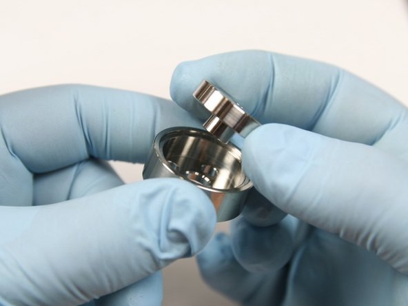 Insert LP poppet in LP poppet basket so stem of poppet goes through center hole in basket