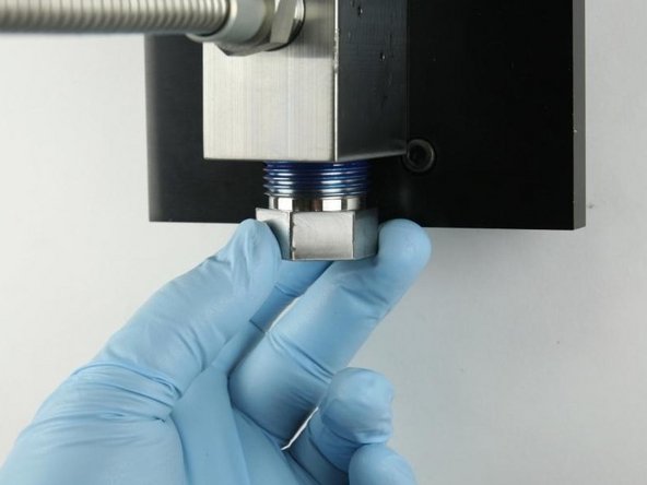 Thread the high-pressure gland fitting into the bottom of the valve body.