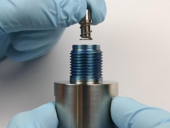 Put the outlet poppet and the poppet spring with the spring first into the outlet body.