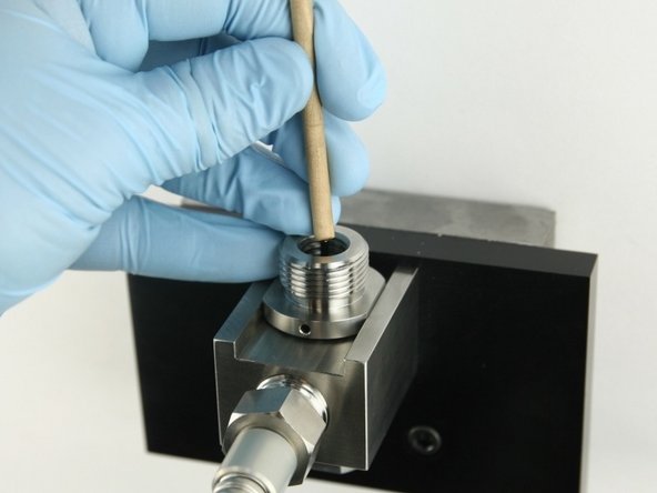 Use the dowel to push the poppet stem down until the back-up ring is flush with the top of the bore.