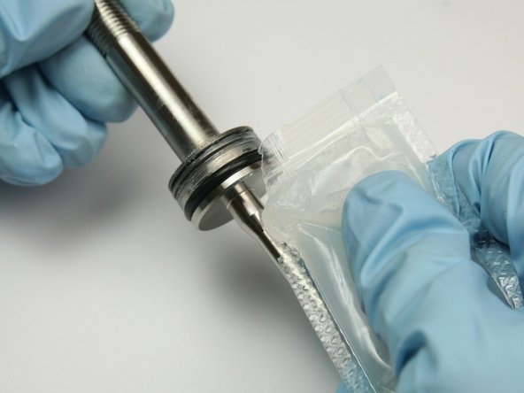 Apply a layer of high vacuum grease on the non-threaded side of the swivel shaft.