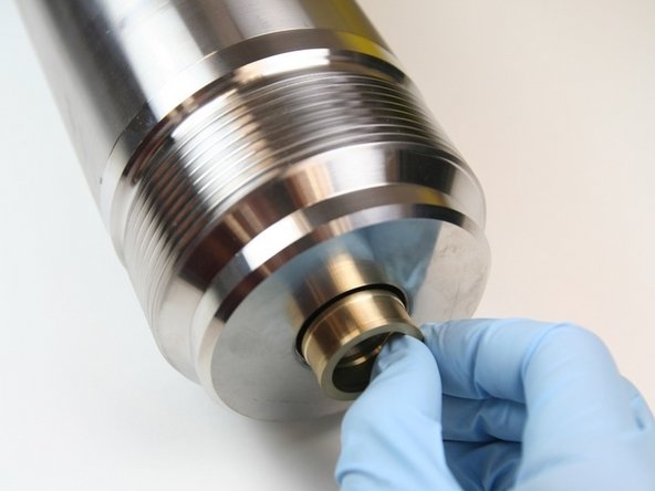Put the brass packing follower into the high-pressure cylinder, behind the dynamic seal back-up.