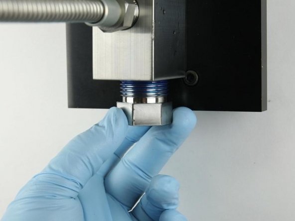 Thread the high-pressure gland fitting into the bottom of the valve body.