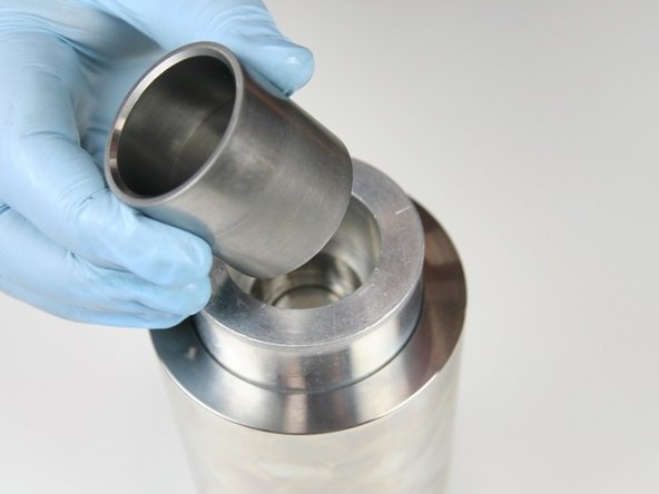 Put the sleeve into the locator tool with the tapered end up.