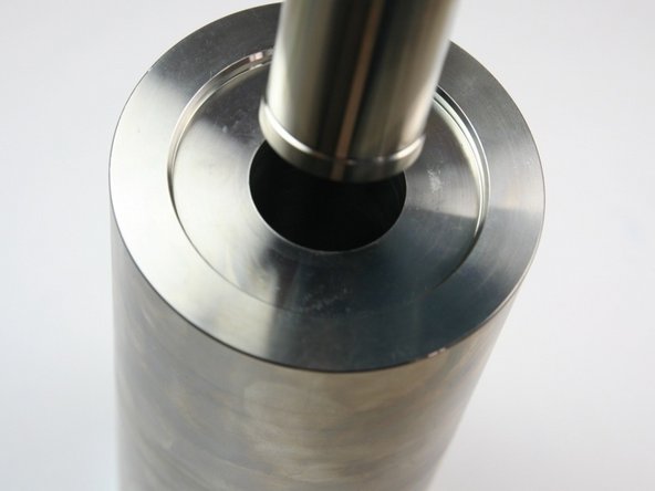 Put the spacer tube with the poppet and basket up into the high-pressure cylinder.