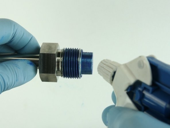 Clean the valve nut threads and the top of the  nozzle tube of all Blue Goop.
