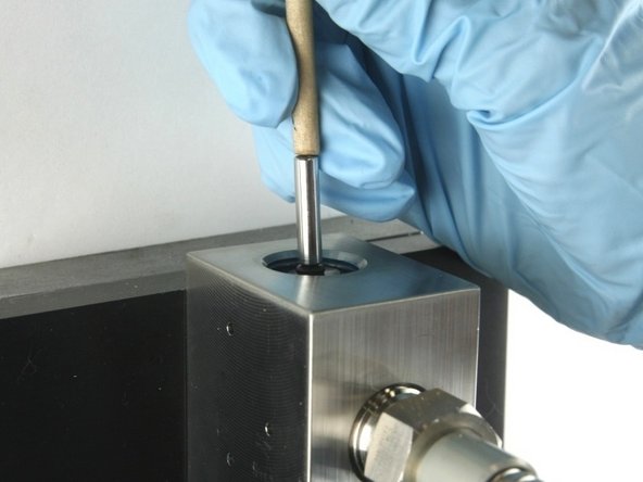 Push the valve stem with the dowel until it bottoms out.