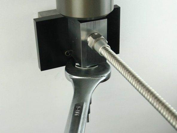 Tighten the high-pressure gland fitting using a 1-1/4&quot; wrench.