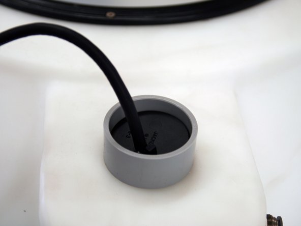 Drop the float gauge into the tank and bring the plug end through the grey opening at the top. Attach the rubber stopper to the cord and reinsert into the grey opening. Make sure to adjust the cord to be 10” from top of tank to metal bullet.