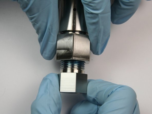 Unthread the 3/8" to 1/4" adapter from the outlet fitting.