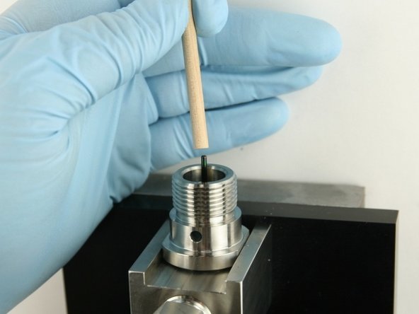 Use the dowel to push the poppet stem down until the back-up ring is flush with the top of the bore.