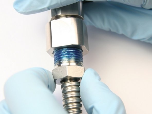 Unthread the 3/8&quot; high-pressure gland from the outlet adapter.