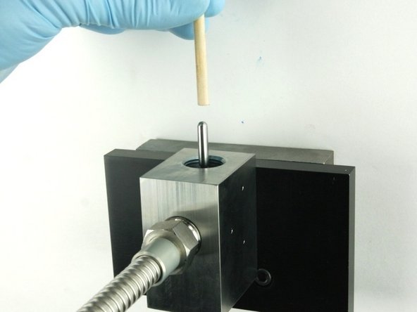 Push the valve stem with the dowel until it bottoms out.