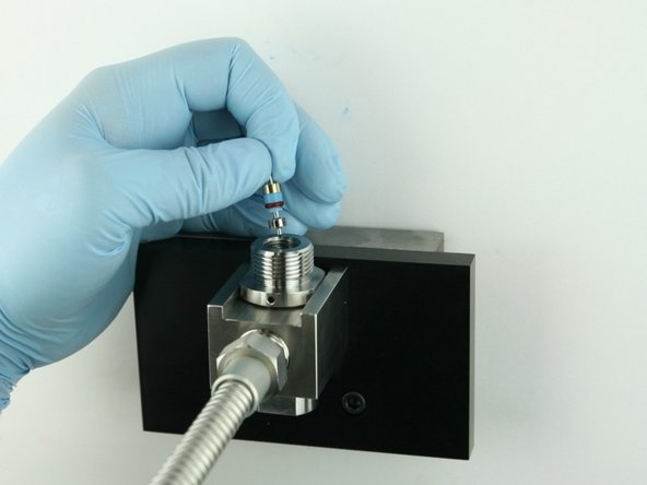 Put the poppet stem, with the point down, at the top of the valve body.