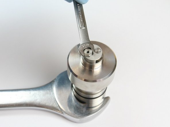 Tighten the retaining screw into the check valve body using a 5/16&quot; and 1-1/4&quot; wrench.