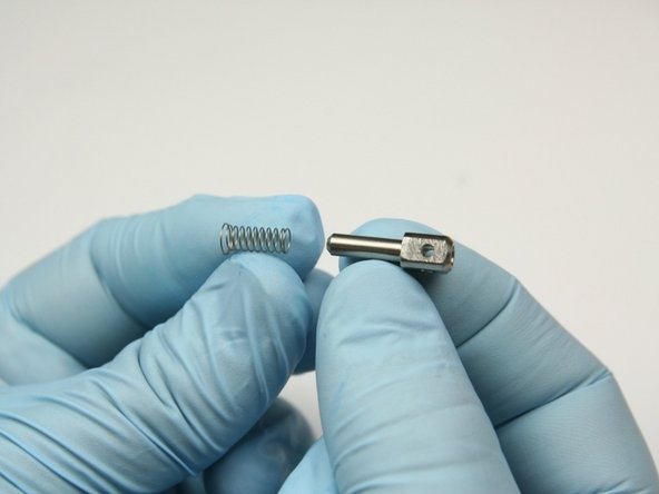 Place the high-pressure spring on the  poppet pin with the flared end away from the poppet pin.