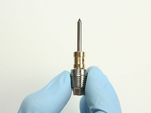 Slide the bushing onto the point of the needle with the chamfered end towards the back-up screw.