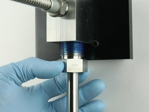 Thread the high-pressure gland fitting into the bottom of the valve body.