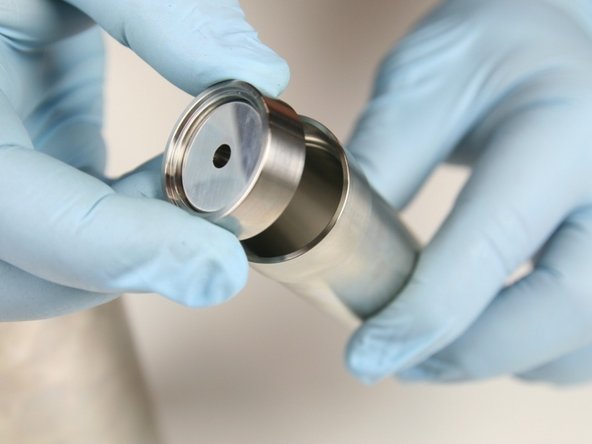 Put the low-pressure poppet and basket into the spacer tube.