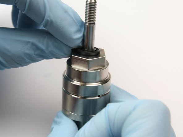 Put the wiper over the swivel shaft and down into the top of the bearing half of the swivel housing.