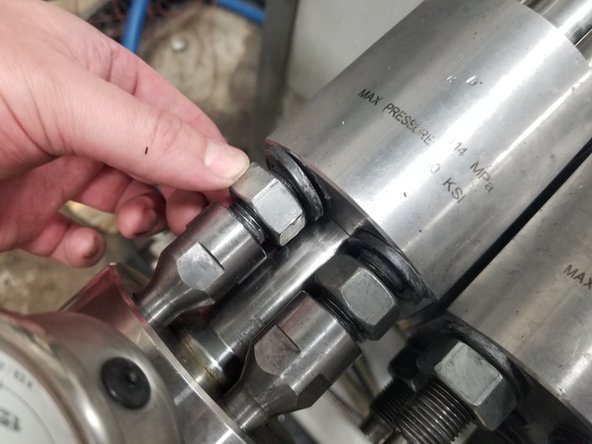 While tool is pressurized, loosen the four nuts a few turns by hand