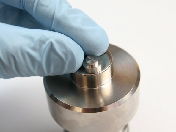 Put the inlet poppet from the kit with the larger surface down on top of the check valve body over the non-threaded hole.