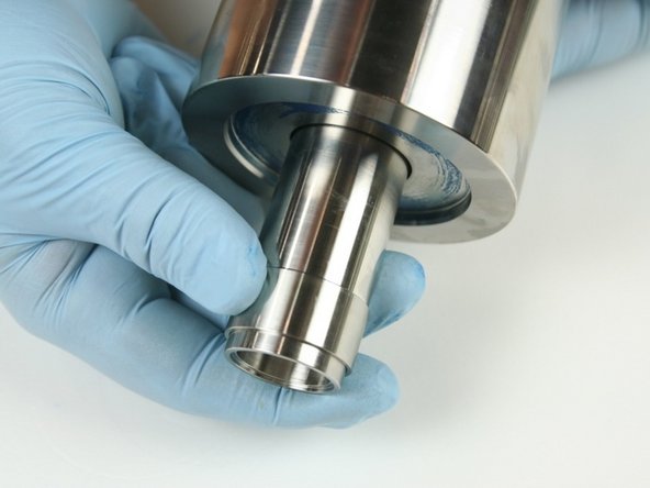 Remove the spacer tube and low-pressure poppet basket from the high-pressure cylinder.