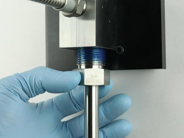 Thread the high-pressure gland fitting into the bottom of the valve body.