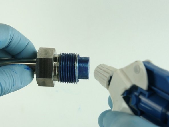 Clean the valve nut threads and the top of the  nozzle tube of all Blue Goop.