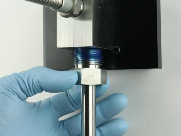 Thread the high-pressure gland fitting into the bottom of the valve body.