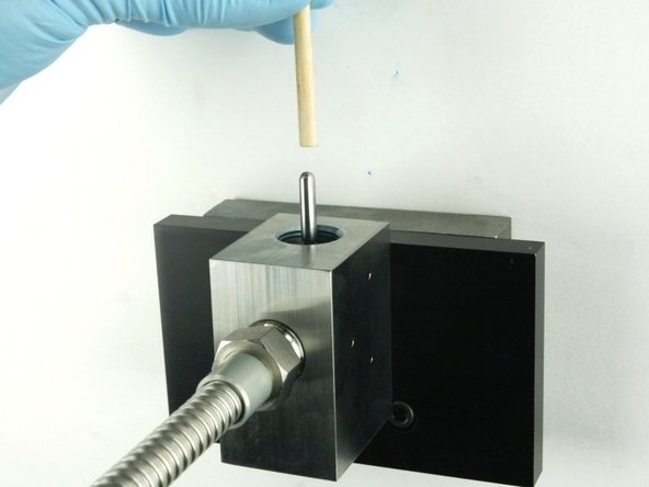 Push the valve stem with the dowel until it bottoms out.