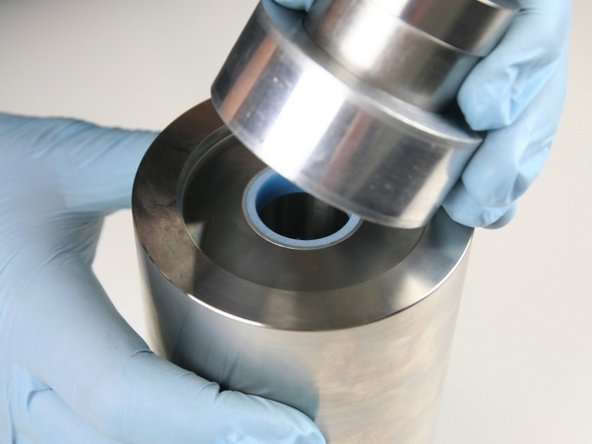 Hold the sleeve down against the  cylinder with one hand to be sure it doesn't raise up while installing the hoop.