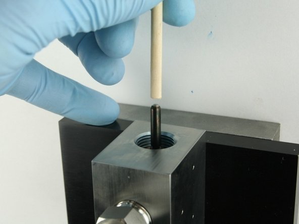 Push the valve stem with the dowel until it bottoms out.