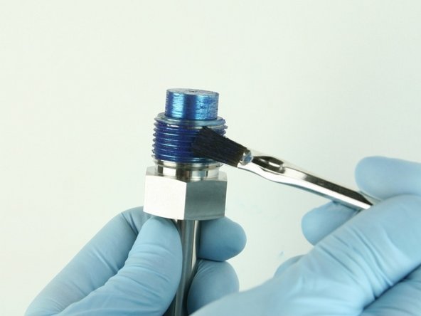 Reapply Blue Goop to the threads of the high-pressure gland fitting and to the top of the nozzle tube.