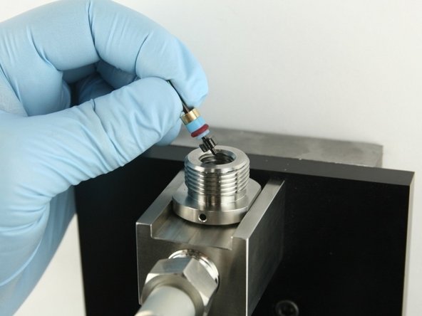 Put the poppet stem, with the point down, at the top of the valve body.