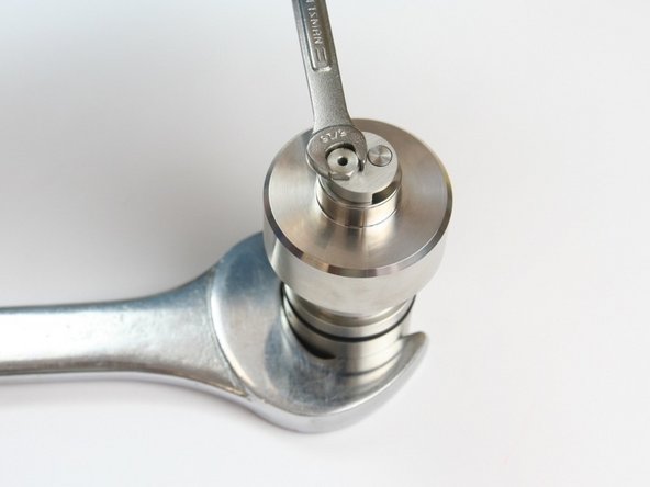 Loosen the retaining screw from check valve body using 5/16&quot; and 1-1/4&quot; wrench.