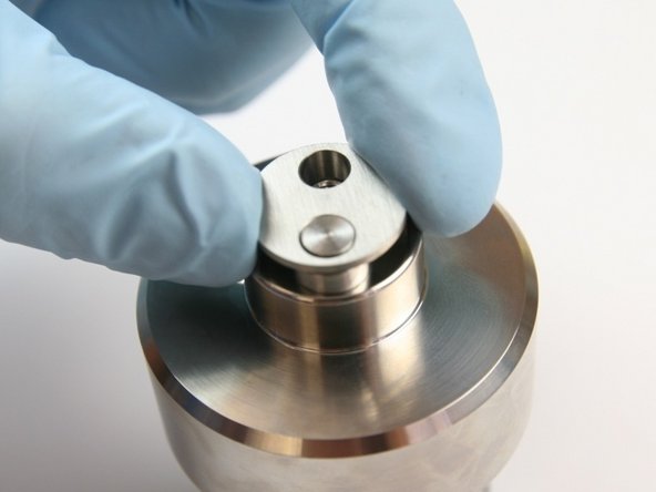 Put the inlet poppet housing over the inlet poppet on top of the check valve body.