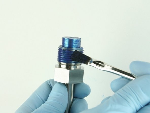 Reapply Blue Goop to the threads of the high-pressure gland fitting and to the top of the nozzle tube.