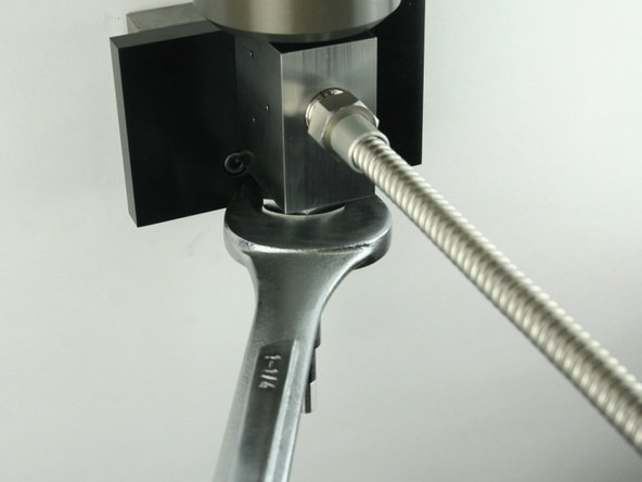 Tighten the high-pressure gland fitting using a 1-1/4&quot; wrench.