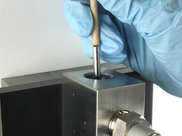 Push the valve stem with the dowel until it bottoms out.