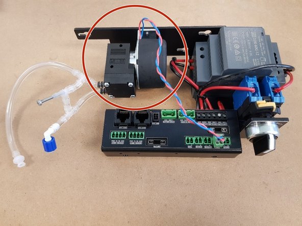 Unscrew the pump from its mounting bracket.