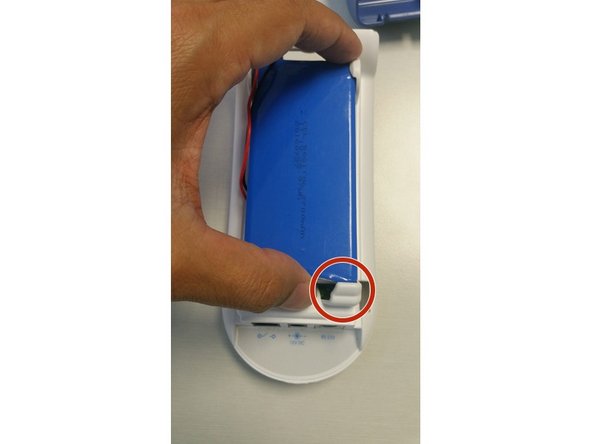 Push the top of the battery down so it's secured under the two top clips.