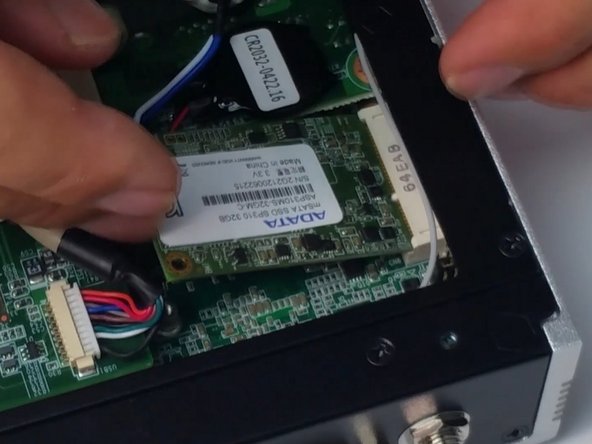 Carefully insert the new SSD and screw in to place.