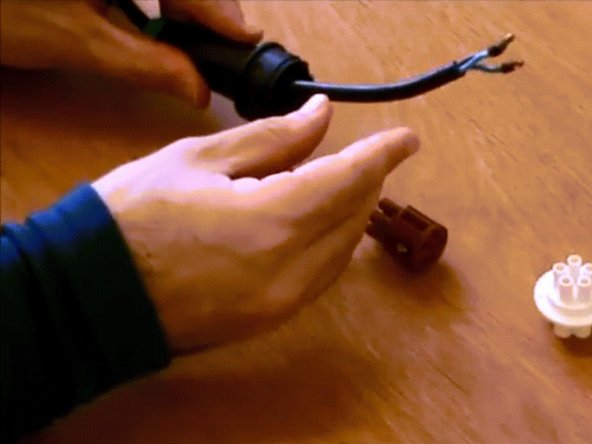 Thread the plug components over the power cable in the following order: nut gland, soft green gland, connector.